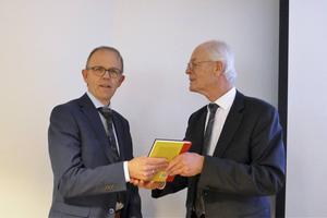Cees van de Beek van uitgeverij Buijten en Schipperheijn overhandigt het eerste exemplaar van het boek ”Het protestantse vaderland. Denken over natie, volk en kerk, 1939-2019” aan ds. C. van Sliedregt, voorzitter van de Willem de Zwijgerstichting. beeld RD