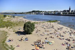 Badgasten langs de Waal bij Nijmegen. De kwaliteit van open zwemwater neemt door de hoge temperaturen snel af. beeld ANP, Piroschka van de Wouw