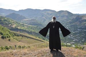 De orthodoxe priester Ter Abel bidt voor vrede bij het dorp Movses aan de grens van Armenië en Azerbeidzjan. beeld AFP