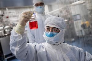 Een Chinese wetenschapper onderzoekt met het Chinese coronavaccin. beeld AFP, Nicolas Asfouri