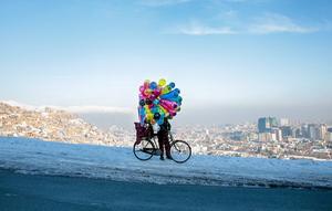 Een Afghaanse straathandelaar met zijn ballonnen op een heuvel in Kabul. beeld EPA