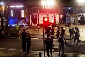 De Rambla drie jaar geleden. Op de achtergrond de witte bestelbus waarmee jihadisten een bloedbad aanrichtten onder de mensenmassa. beeld EPA, Quique Garcia