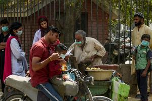 Klanten bij een straatverkoper in Karachi, Pakistan. beeld AFP