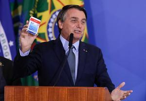 De Braziliaanse president Bolsonaro met een pakje hydroxychloroquine, september dit jaar. beeld AFP, Sergio Lima