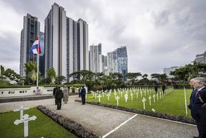 Kranslegging op Menteng Pulo. ”Opdat zij met ere mogen rusten”, staat op de muur. Hier liggen 4270 jonge Nederlanders begraven. beeld ANP, Frank van Beek