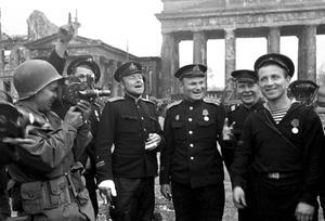 Een Amerikaan filmt Russische militairen voor de Brandenburger Tor in Berlijn. beeld AFP