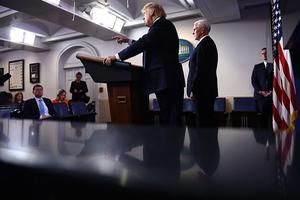 De Amerikaanse president Trump (l.), geflankeerd door vice-presicent Pence, tijdens zijn dagelijkse persconferentie over de strijd tegen het coronavirus. beeld AFP, Brendan Smialowski
