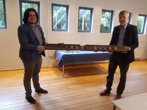 Dolf Tamminga (r.) overhandigt een stuk kastwerk van een oud Gronings orgel aan Sander Booij. beeld Sander Booij