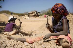 Foto: Congolese vrouw breekt met haar kind stenen uit een kobaltmijn. beeld AFP, Junior Kannah