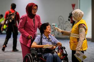 Reizigers op een vliegveld in Jakarta, Indonesië, worden gecontroleerd. beeld EPA