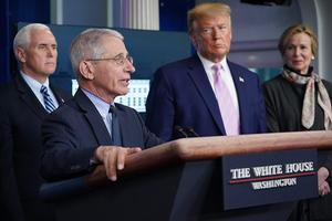 De Amerikaanse president Trump is het niet eens met de waarschuwing van immunoloog Anthony Fauci (l.) om de Amerikaanse economie niet te snel te heropenen. beeld AFP