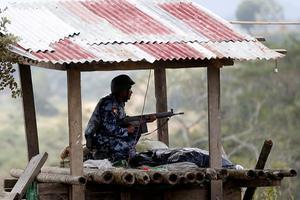 Een grenswacht van Myanmar bemant zijn post in het noorden van de staat Rakhine. In deze regio is nationalistische groepering Arakan Army actief. beeld EPA, Hein Htet