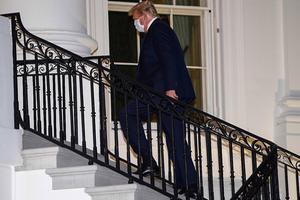 Trump loopt het Witte Huis binnen. beeld AFP, NICHOLAS KAMM