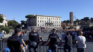 Tegenstanders van de coronamaatregelen van de Italiaanse regering slaagden er zaterdag niet in grote massa’s op de been te brengen. Van een afstand hield de politie toezicht op de betoging in Rome.  beeld Ewout Kieckens