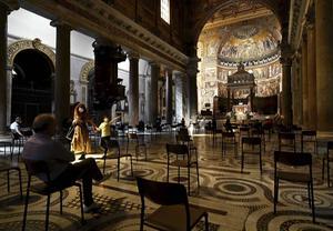 Rooms-katholieken bidden in de oudste Mariakerk van Rome, terwijl ze de afstandregels in acht nemen. beeld AFP, Vincenzo Pinto