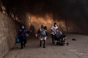 Migranten vluchten uit kamp Moria. beeld ANGELOS TZORTZINIS / AFP