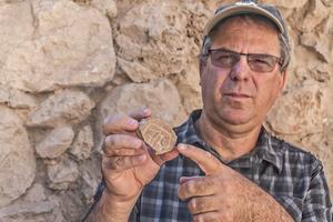 Prof. Yuval Gadot van de Tel Aviv Universiteit met de zegel. beeld Shai Halevy, Israëlische Oudheidkundige Dienst, IAA