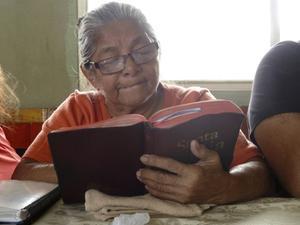 Een vrouw uit Ecuador leest in haar Bijbel. beeld ZGG