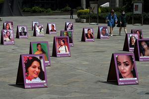 Foto's van slachtoffers, omgekomen door geweld tegen vrouwen. De foto's staan in Medellin, een stad in Colombia. beeld AFP, Joaquin Sarmiento