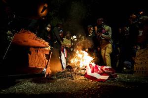 Demonstranten verbranden een Amerikaanse vlag tijdens een protest tegen racisme en politiegeweld in het centrum van de Amerikaanse stad Portland in de staat Oregon. beeld EPA, Etienne Laurent